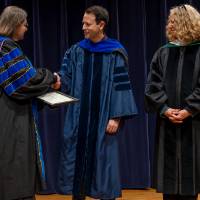 Christine shaking hands with faculty, and Provost